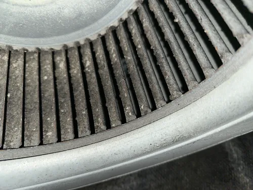Dust caked between the blades of an AC blower wheel