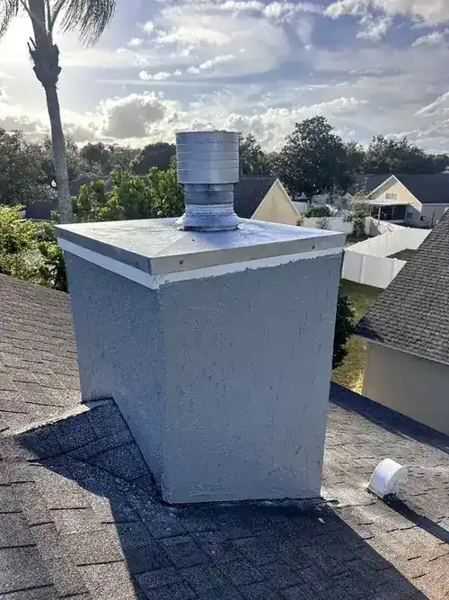 Clean chimney exterior with new cap against blue sky