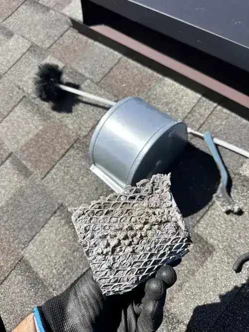 Chimney cleaning brush and tools on a roof
