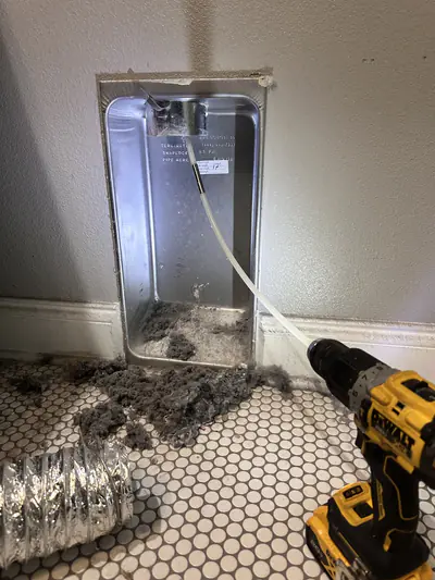 Lint being cleared from a dryer vent